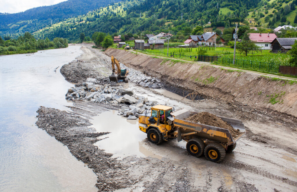 truck and excavator on a construction site in river